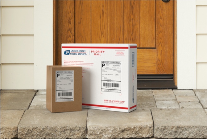 Priority Mail boxes on a house stoop awaiting pickup.